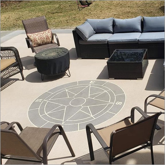 a compass stencil incorporated on concrete overlay on a patio done in light brown concrete 